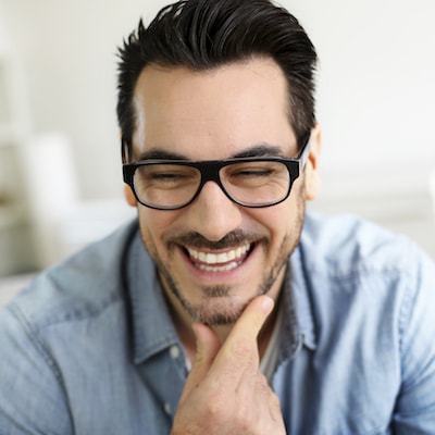 Headshot of a man laughing after successfully having an extraction at Midtown Dental Excellence.