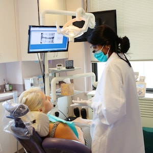 Photo of a Midtown cosmetic dentist consulting with a patient in the dental chair