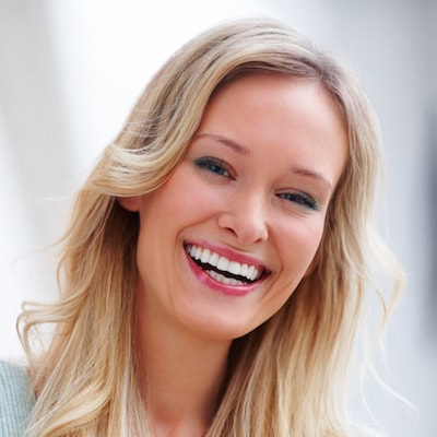 Blonde woman smiling after receiving inlays and onlays as part of our cosmetic dentistry in NYC.