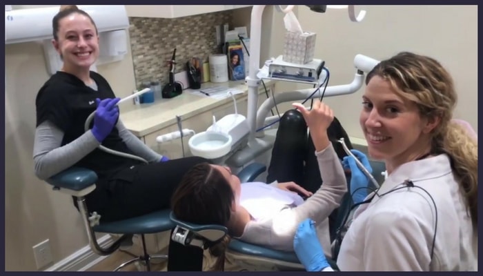 2 team members and a patient in the dental chair smiling during the dental procedure